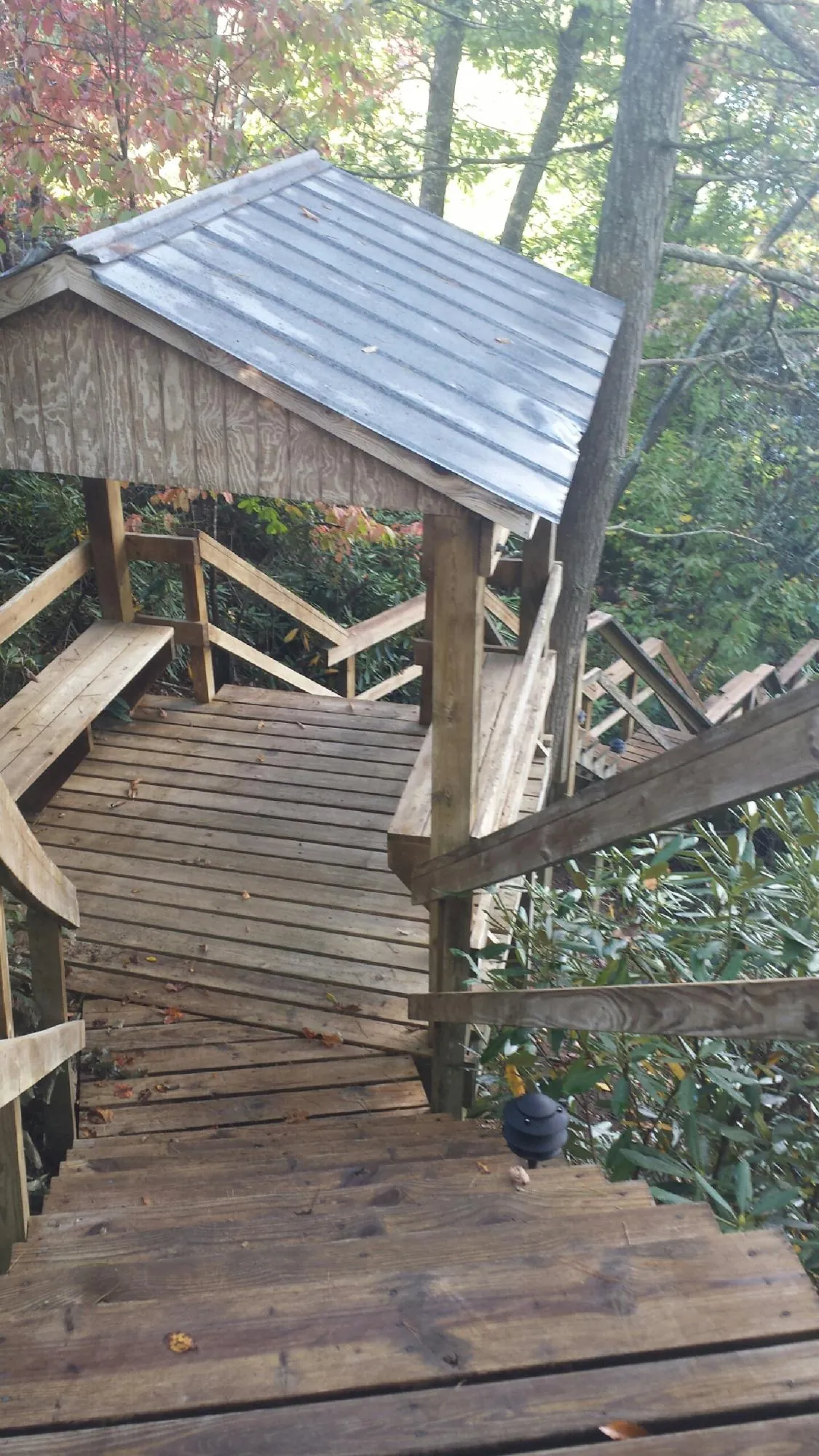 Metal roofed shelter over wooden steps on a wooded walkway — Skylight Repair & Installation work by our crew in Oxford